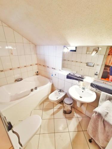 埃尔德Apartman Poirot Balcony的带浴缸、两个盥洗盆和浴缸的浴室。