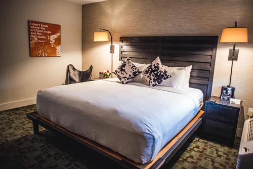 费尔菲尔德Hi-Ho: A Hi-Tech Hotel的卧室配有带枕头的大型白色床