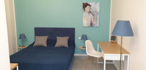 米兰Milano Dreams的一间卧室配有一张蓝色的床、一张桌子和一张桌子