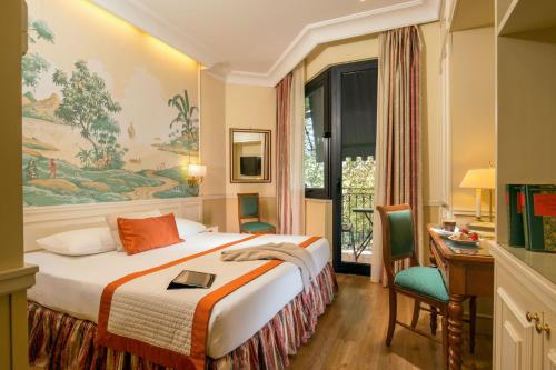 罗马Donna Laura Palace by OMNIA hotels的配有一张床、一张书桌和一扇窗户的酒店客房
