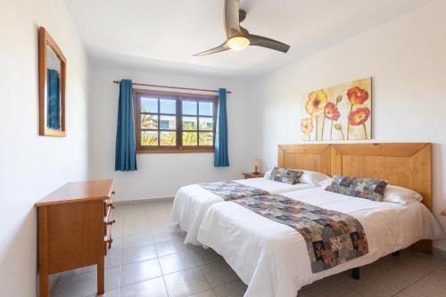 卡门港佩妮塔公寓的一间卧室配有一张床和吊扇