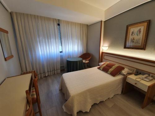 博伊罗Hotel Alda Boiro的酒店客房配有一张床铺和一张桌子。