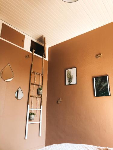 科涅克chambre salle de bain partagée的卧室设有梯子,墙上挂着一些图片