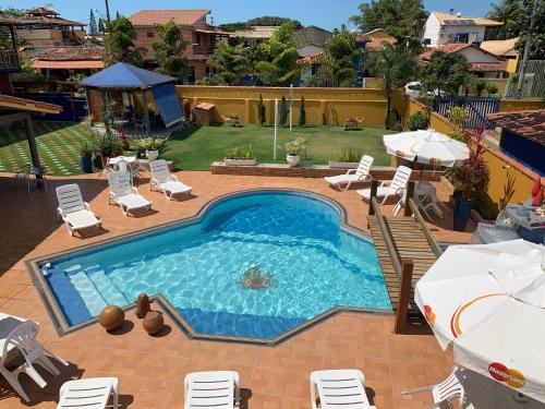 伊塔乌纳斯珊瑚旅馆的庭院内一个带椅子和遮阳伞的游泳池