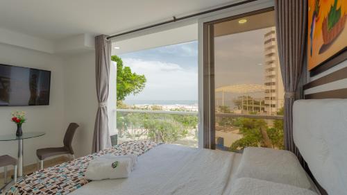 卡塔赫纳Hollywood Beach Suite的一间卧室配有一张床,享有海景