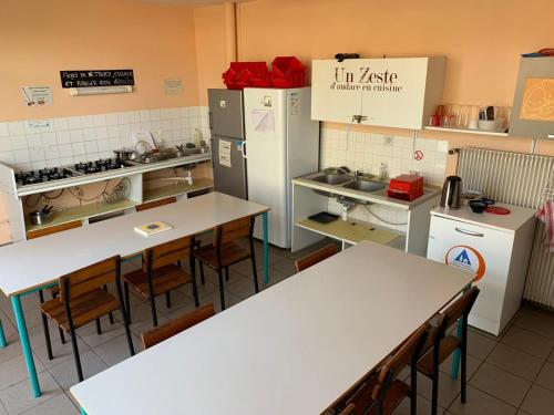 勒帕莱Auberge de Jeunesse HI Belle-Île-en-Mer的餐厅内带桌子和冰箱的厨房