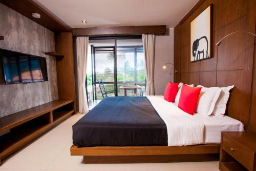 拉迈苏梅岛艾姆尼提阿帕图尔酒店的一间卧室配有一张带红色枕头的大床
