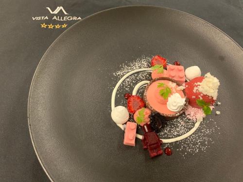 伊施格尔阿莱格拉维斯塔酒店的黑盘上的甜点,包括草莓和冰淇淋