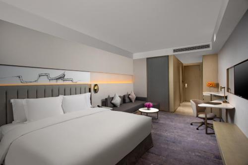 福州福州融侨水乡皇冠假日酒店的酒店客房设有一张大床和一间客厅。