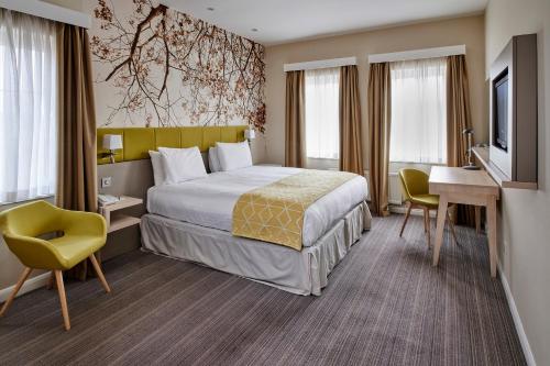 科比假日科尔比凯特灵A43酒店的酒店客房配有一张床、一张书桌和一台电视。