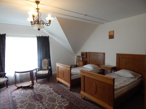 Iecava布林西斯汽车旅馆的一间卧室配有两张床和吊灯。