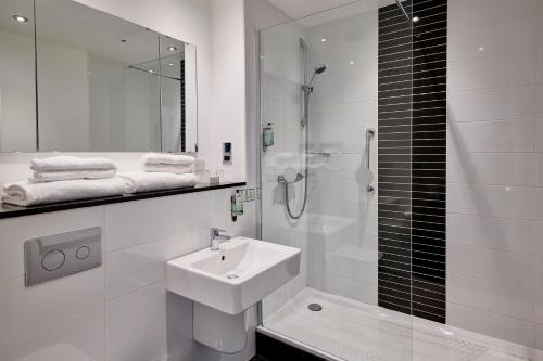 科比假日科尔比凯特灵A43酒店的白色的浴室设有水槽和淋浴。