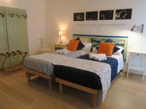 帕多瓦Foresteria Conti, sulle tracce di Shakespeare的一间卧室配有两张橙色和蓝色的床