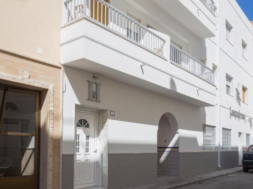 卡沃内拉斯Hostal Las Palmas的白色的建筑,侧面设有阳台