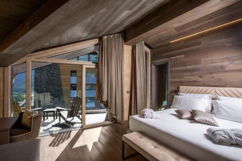 布勒伊-切尔维尼亚Bergman Mountain Hotel的一间带大床的卧室和一个阳台