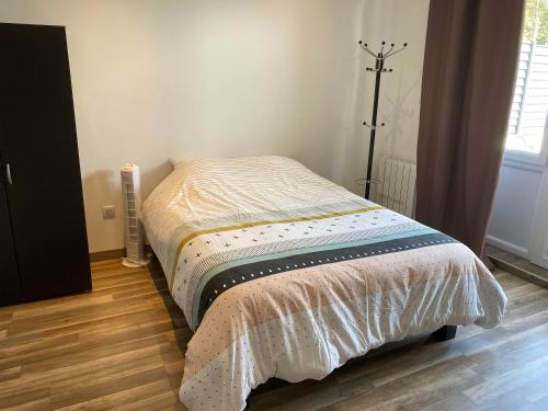 布雷斯地区布尔格Legend- Parking privé Gratuit- Terrasse privée- Wifi - Convert - Alimentec的卧室内的一张小床,铺有木地板