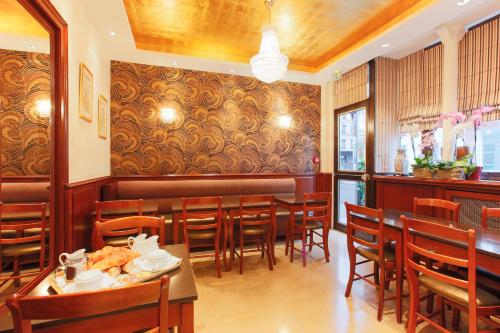 巴黎圣拉扎尔贝尔维尤酒店的餐厅设有1间带桌椅的用餐室