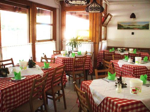 希欧福克夹竹桃住宿加早餐旅馆的餐厅设有红色和白色的布艺桌,配有绿色餐巾
