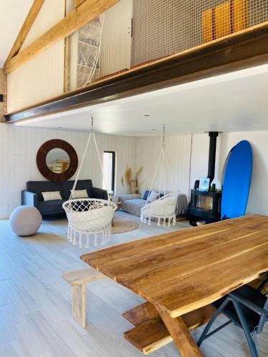 拉康提内勒la P’tite Grange的客厅配有木桌和秋千