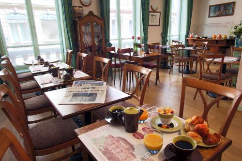 里昂塞尔斯丁酒店的一间餐厅配有桌椅,提供食物