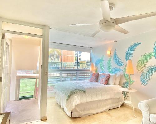 圣胡安KASA El Sol by the Sea with Pool and Parking的卧室配有一张带热带壁画的床铺。