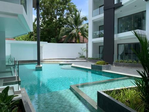卡马拉海滩CYAN Resort Kamala Beach Apartments Condominiums的一座建筑物中央的游泳池