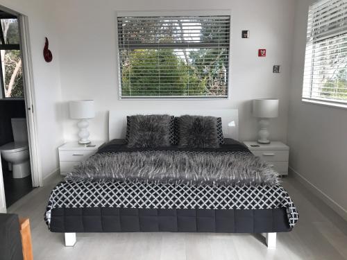 欧尼坦基Sea La Vie - Waiheke Island Luxury Accommodation的卧室设有黑白床和窗户。