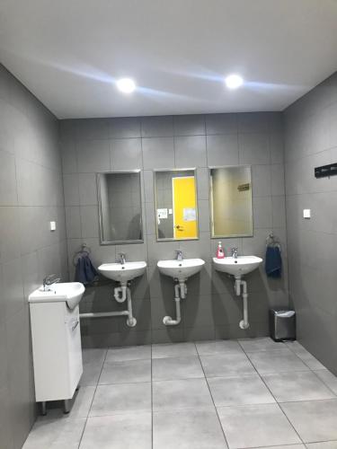 珀斯Perth City Backpackers Hostel - note - Valid passport required to check in的浴室设有3个水槽和3面镜子