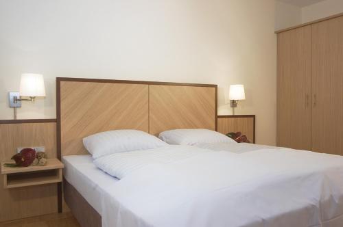 科隆杜姆寄宿公寓式酒店的卧室配有一张带两个枕头的大白色床