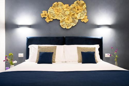 罗马Peony - 13 Piazza Pio XI的卧室配有一张蓝色和白色的床,墙上挂着鲜花