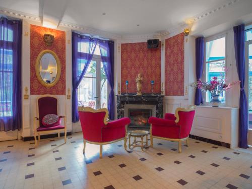 LabordePetit Château的客厅配有红色椅子和壁炉