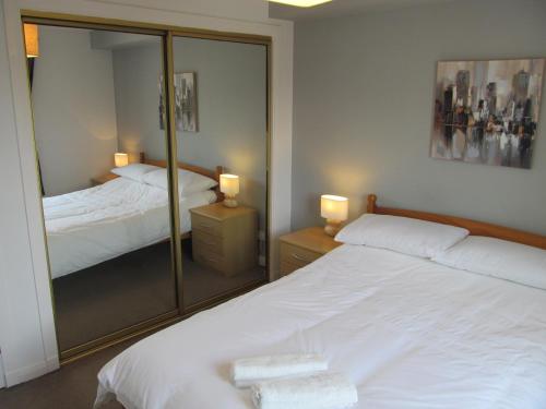 阿伯丁The Granite City - Modern City Centre Apartment的一间卧室配有两张床和镜子