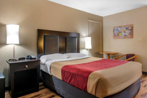 埃文帕克西布林伊克诺旅店的一间卧室配有一张带红色毯子的大床