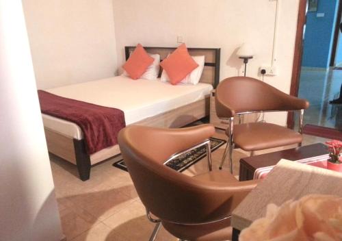 MawanellaMahoya的酒店客房,配有床和椅子