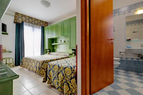 利多迪耶索罗加尔尼圣卡罗酒店的一间带两张床的卧室和一间浴室