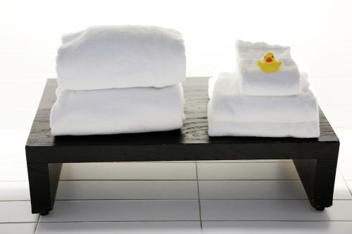 斯德哥尔摩Apartement 24, Hotell的两堆毛巾和一张桌子上的橡皮鸭