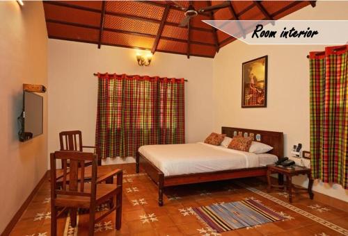 马哈巴利普拉姆Marutham Village Resort的一间卧室配有一张床和一把椅子