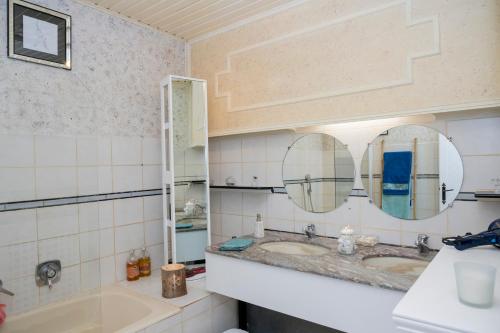 CheminotUne HALTE Quelque PART的浴室设有2个水槽和2面镜子