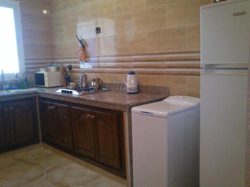 萨伊迪耶Magnifique Appartement Plage Saidia的厨房配有水槽和冰箱
