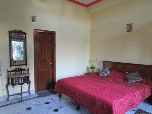 克久拉霍禅宗酒店的一间卧室配有一张红色床罩的床