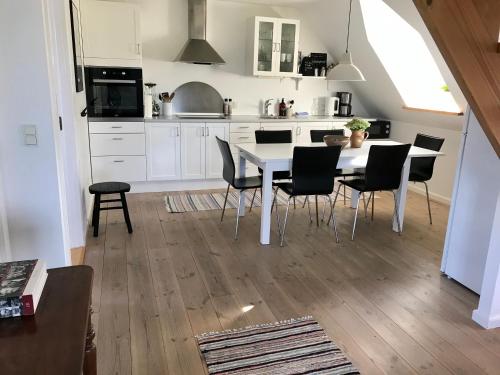 斯坎讷堡Tåning Gl. Mejeri的厨房配有白色的桌椅