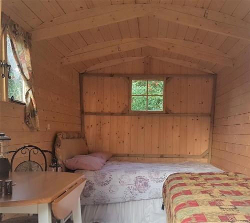 SudburyRum Bridge Gypsy 'Rose'的木制客房内的一间卧室,配有一张床