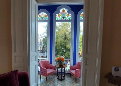 锡切斯瑙赛迪斯塔酒店的客房设有3扇窗户和桌椅。
