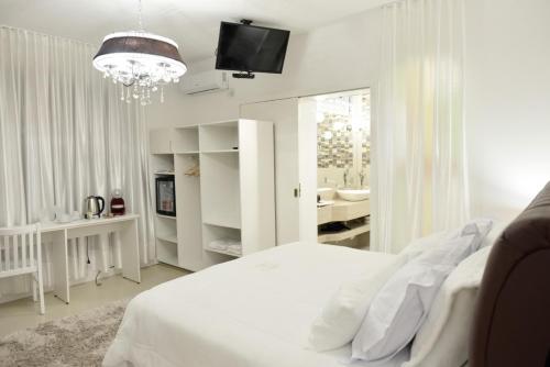 圣玛丽亚Ivlas Boutique Hotel的白色卧室配有一张床和一个吊灯