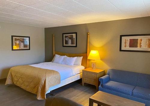 杜波依斯Hotel Veranda DuBois的一间卧室配有一张床和一张蓝色的沙发
