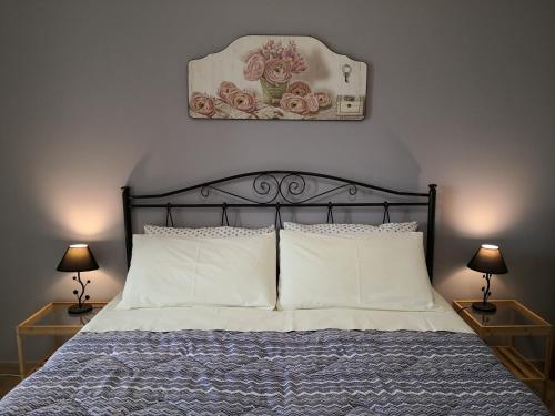科里利亚诺多特兰托B&B Il Papavero Rosso的一张带白色枕头的床和一张墙上的照片