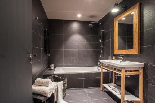 索尔德乌Luxury Alpine Residence with Hot Tub - By Ski Chalet Andorra的一间带水槽、浴缸和镜子的浴室