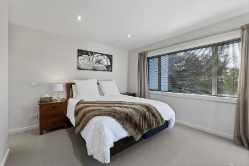 陶波Bay Bliss - Lake Taupo Holiday Home的一间卧室设有一张床和一个大窗户