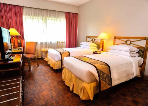 达沃市Waterfront Insular Hotel Davao的酒店客房设有两张床和电视。