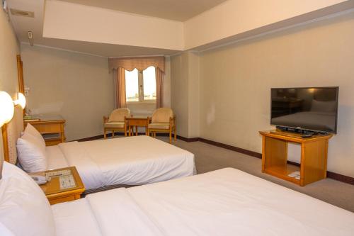 恒春古城恒农假期渡假饭店的酒店客房设有两张床和一台平面电视。